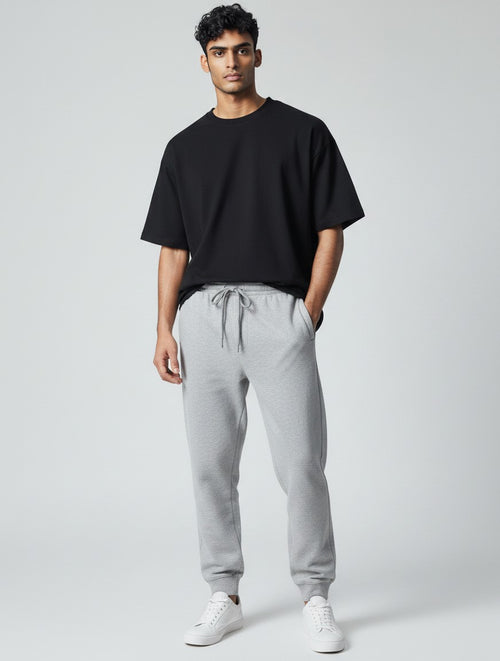 CosmoOtaku unisex grey melange cotton joggers with a tapered fit, ribbed cuffs, and drawstring waist on a model.