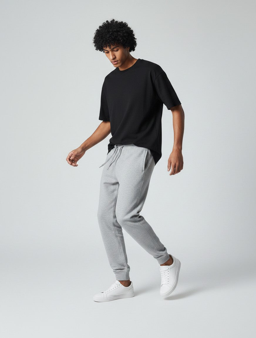 CosmoOtaku grey melange unisex joggers in 260 GSM cotton with ribbed cuffs, worn by a model with a black t-shirt.
