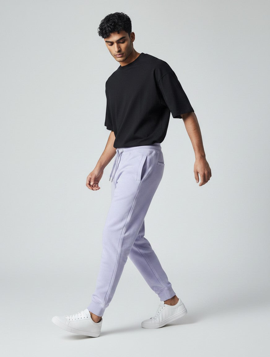 CosmoOtaku lavender cotton joggers on a male model wearing a black t-shirt and white sneakers, side view.