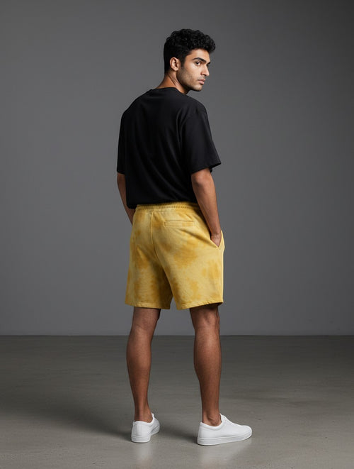 CosmoOtaku mustard yellow sun-washed drawstring shorts worn by a man with a black t-shirt and white sneakers